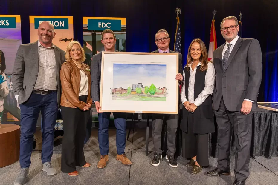 Altru Health System representatives stands with EDC board chair and president and CEO holding a painting that represents the 2025 Klaus Thiessen Impact Award.