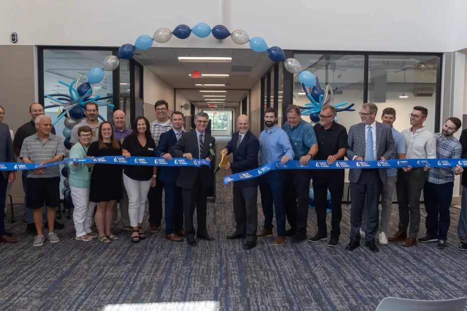 Leaders stand together to cut the ribbon of the Career Impact Academy.