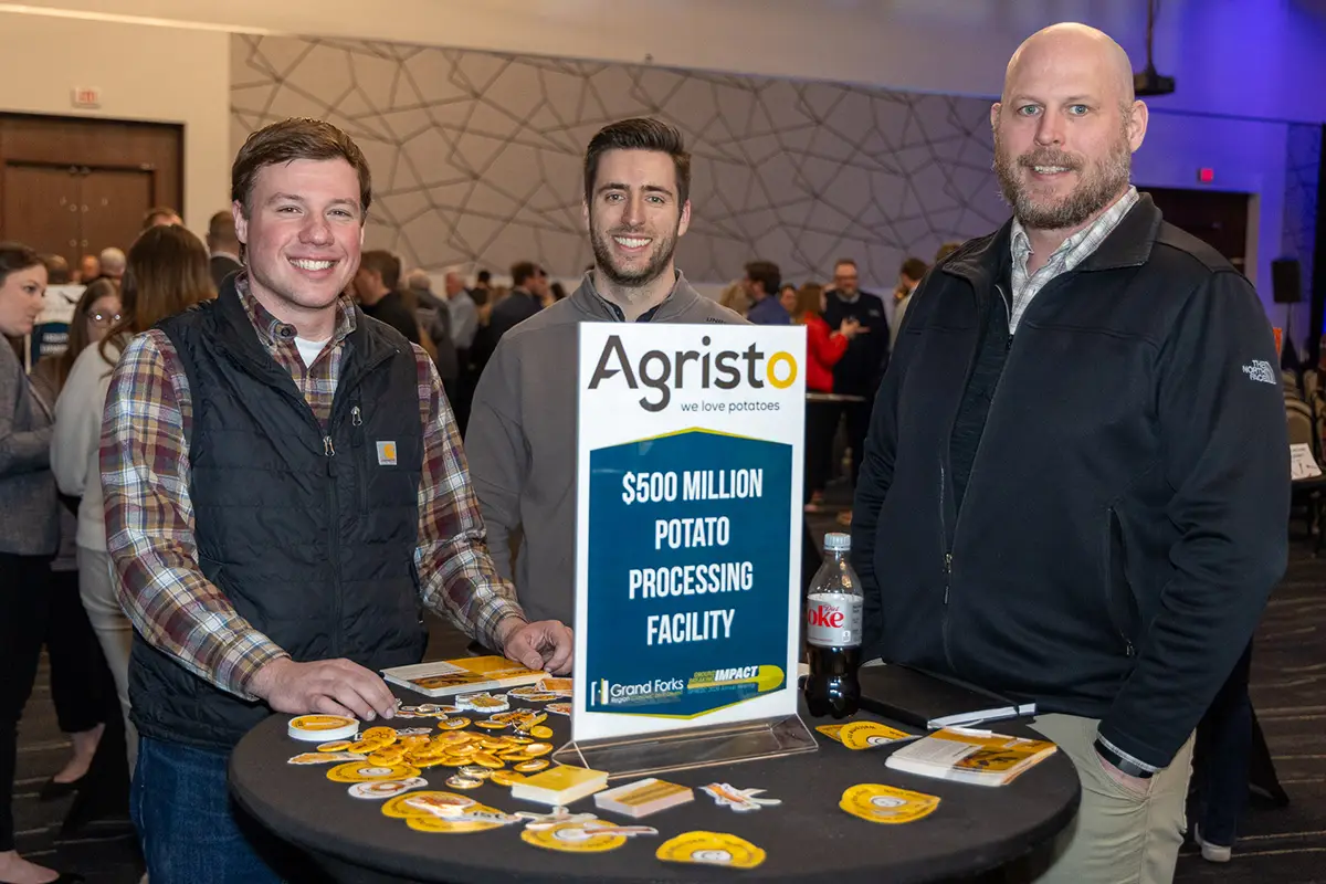 agristo staff members stand together at a cocktail table networking at the annual meeting.