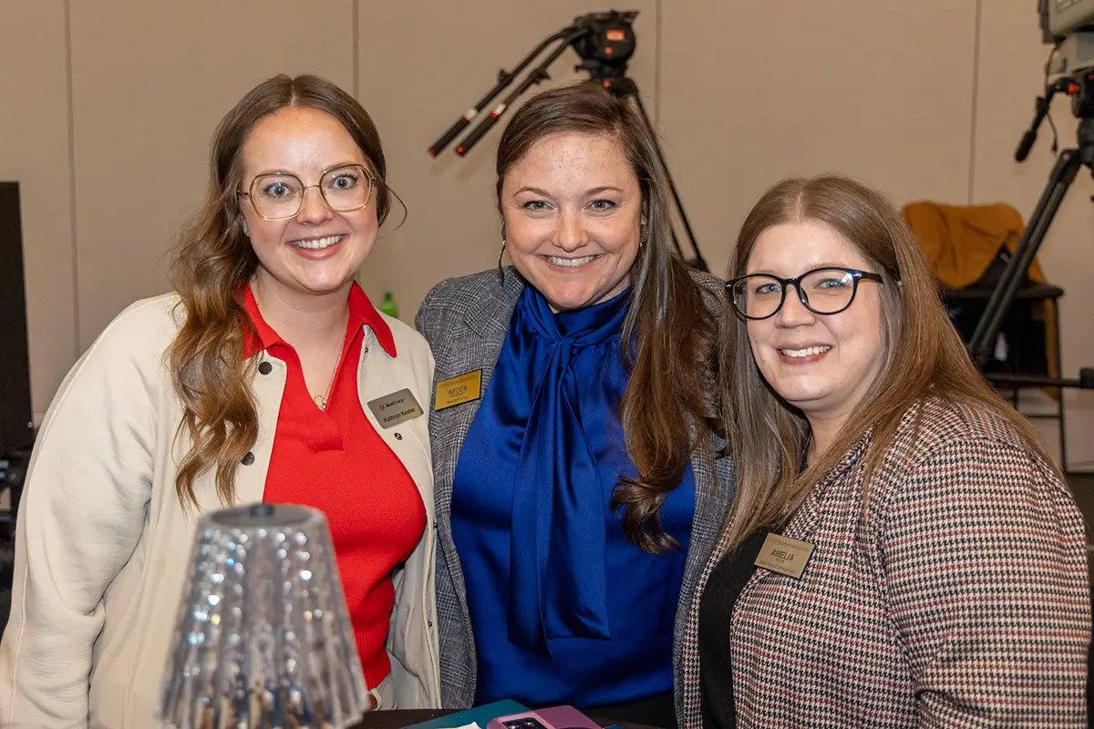 invited guests stand together at the social at the annual meeting.