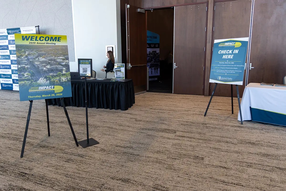 The check-in tables at the 2026 Annual Meeting with the sign.