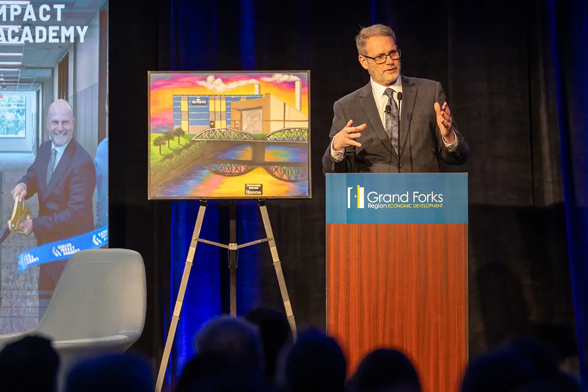 EDC President & CEO Keith Lund speaks at a podium sharing the 2026 impact award at the annual meeting.