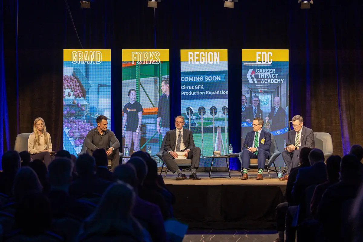 A group of panelists sit on stage delivering remarks at the 2026 annual meeting.